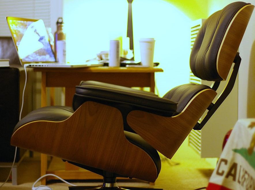 A desk chair, leaning back with a lamp in the background