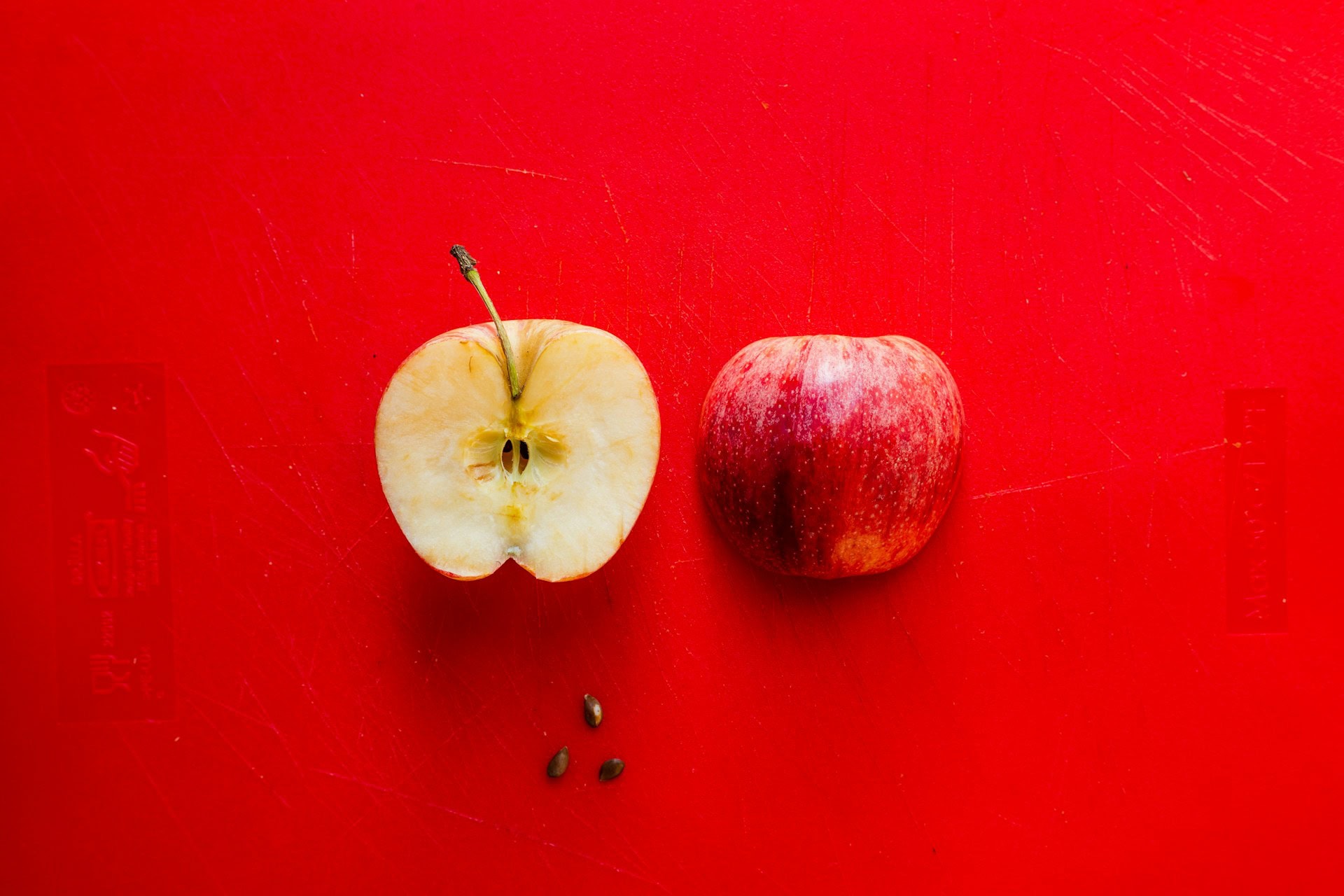 louis-hansel-bPMyJzKhCyA-unsplash Halved apple on red background